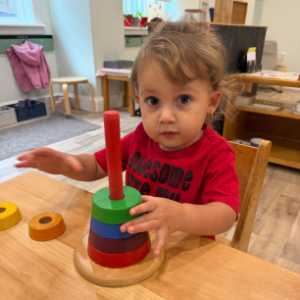 Toddler using ring stacking tower